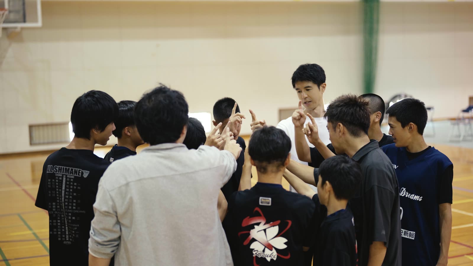 円陣を組む中学生と指導者