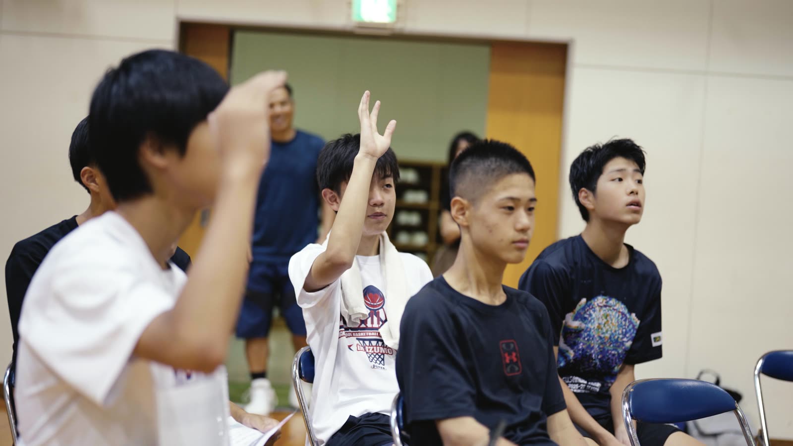 ミーティングで手を挙げる中学生たち